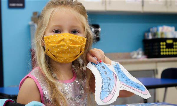 girl smiles while wearing mask